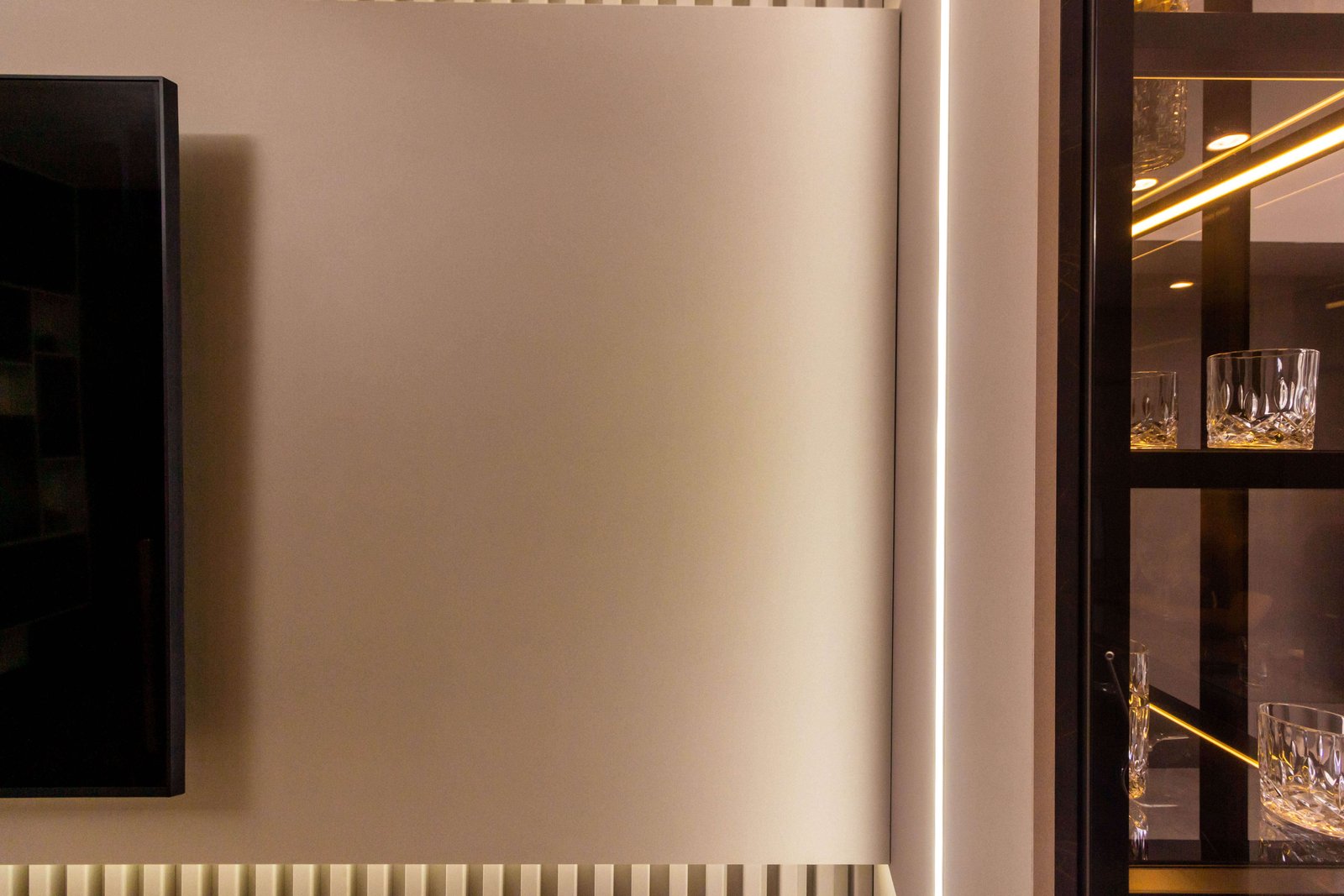 Outro detalhe em close da iluminação vertical oculta atrás do painel, destacando a textura do material.