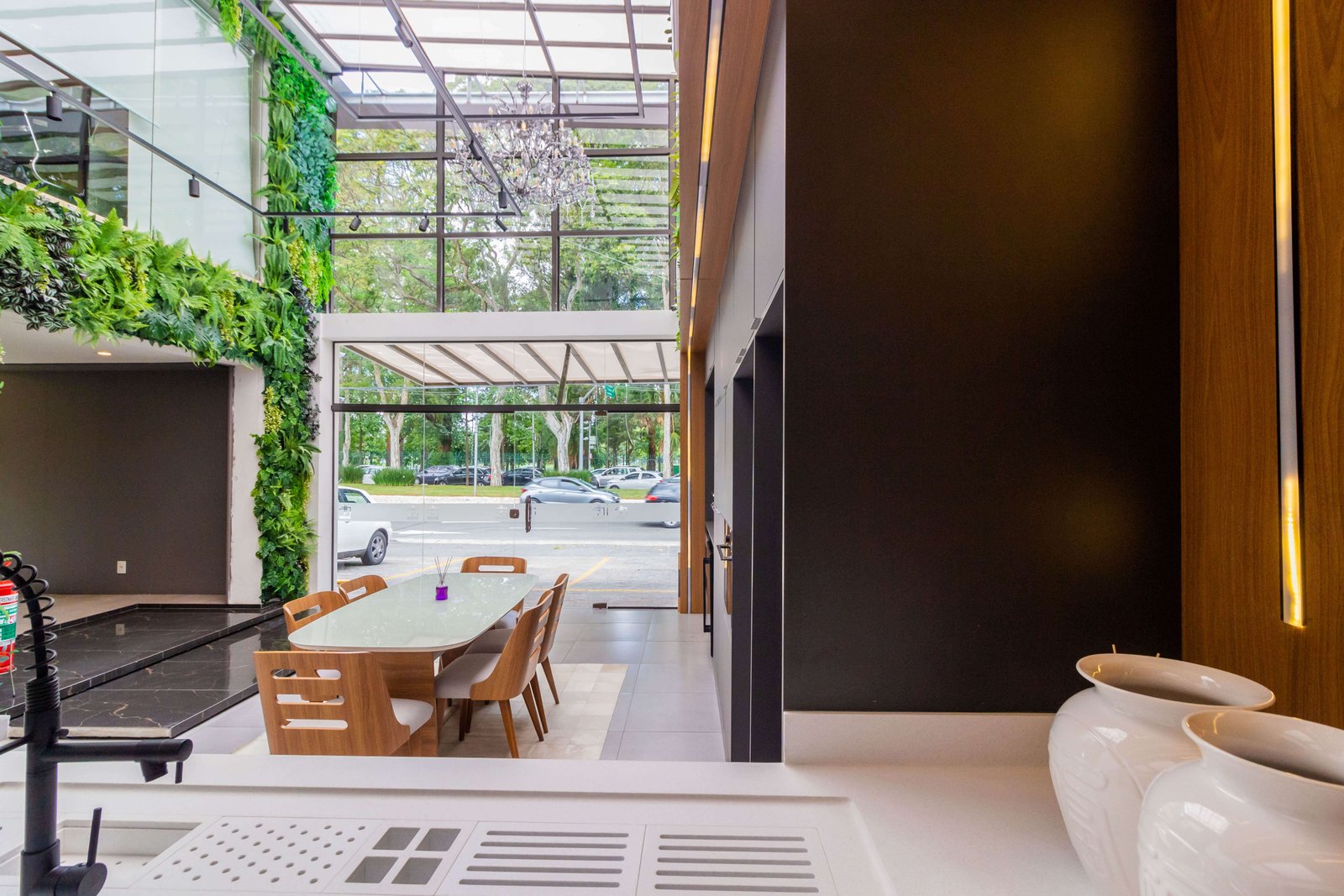 Bancada de área gourmet planejada com churrasqueira de inox embutida e painel de madeira com iluminação LED embutida, criando um ambiente moderno e aconchegante em São Paulo.